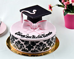 Custom pink and black cake with word Congratulations and graduation hat on top